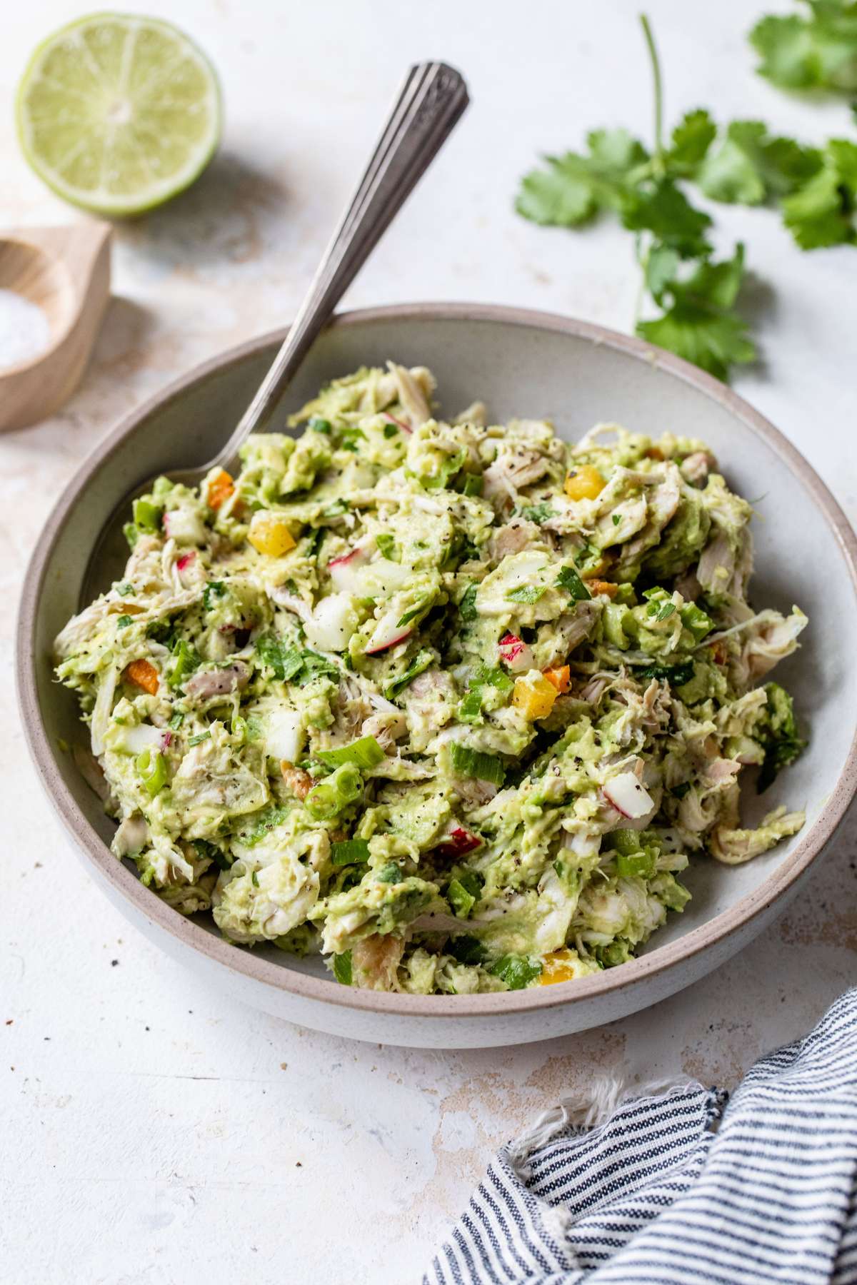 Avocado chicken salad in a bowl with a serving spoon.
