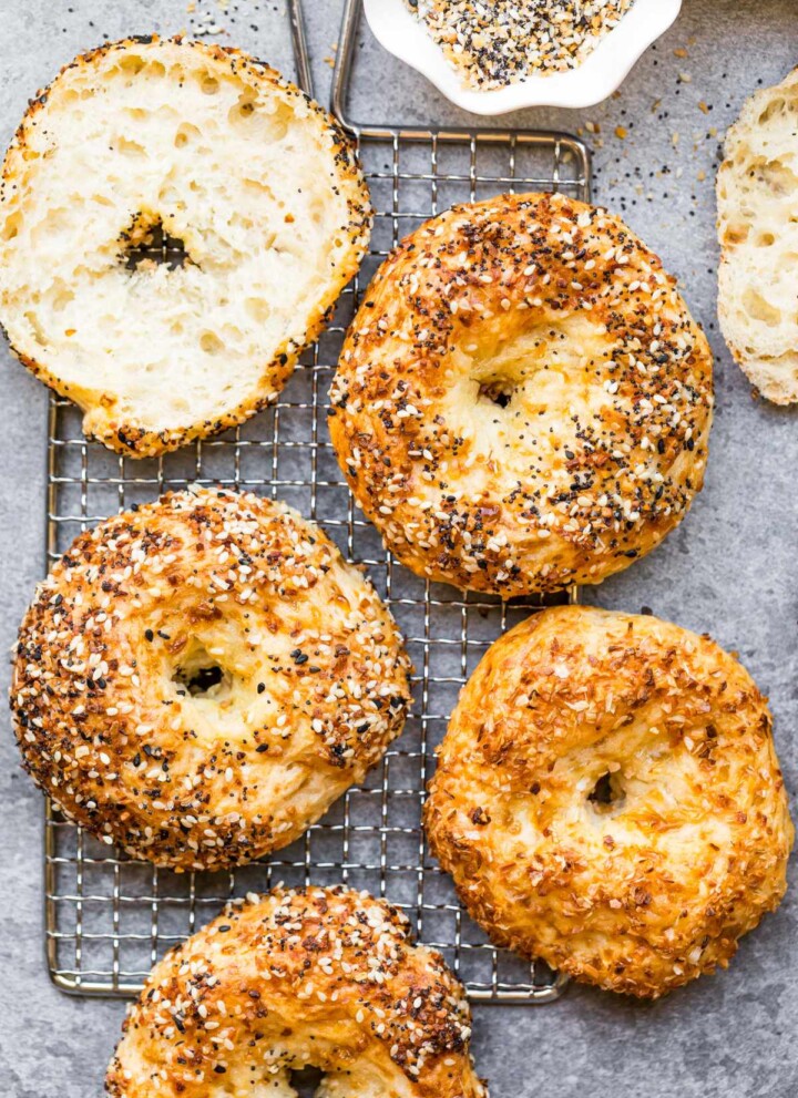 Baked protein bagels with cottage cheese on a cooling rack.