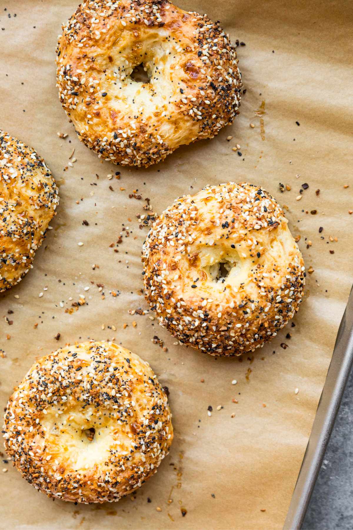Baked protein bagels on a pan lined with parchment paper.