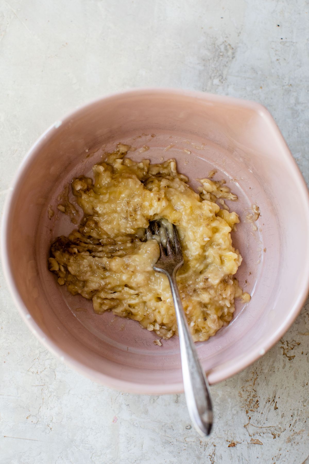 Mashing banana in a bowl with a fork.