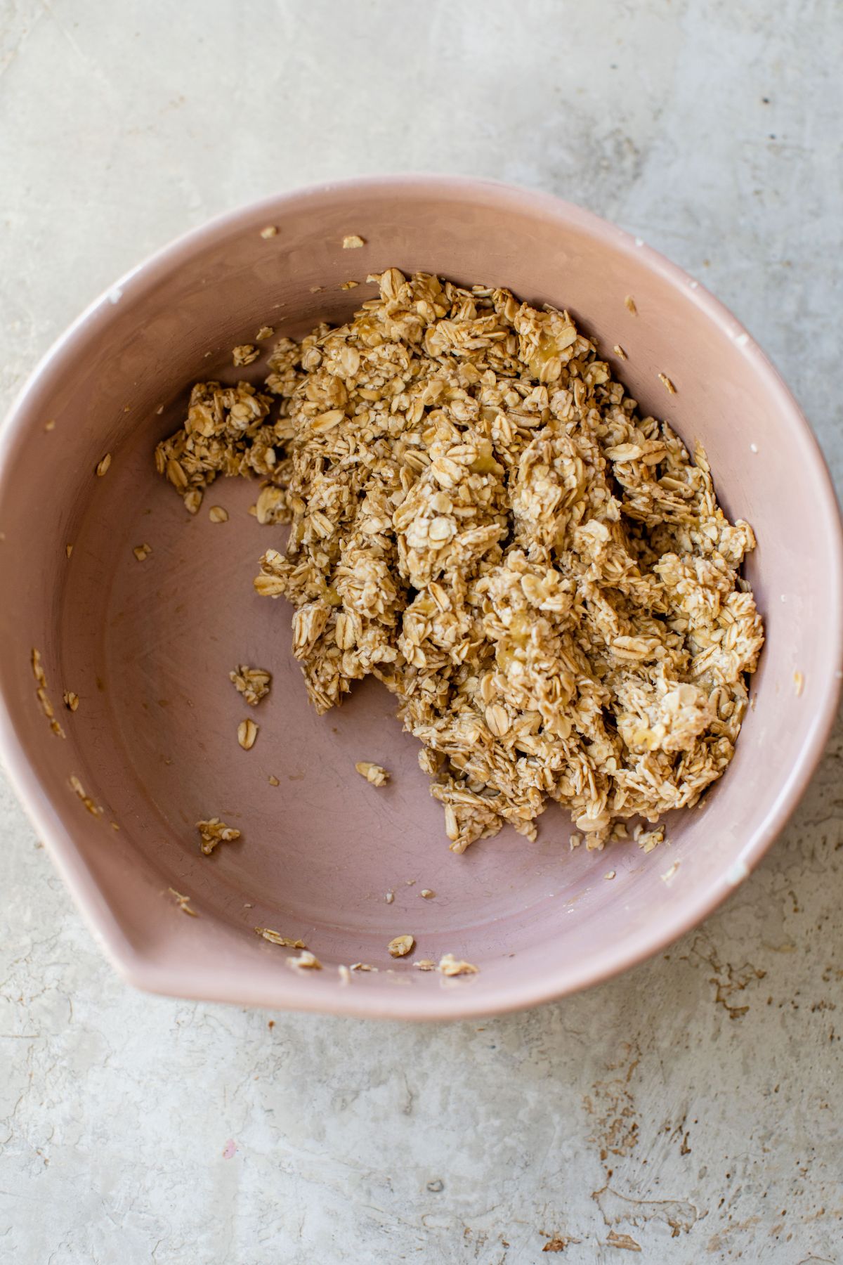 Mixing oats with mashed banana in a bowl.