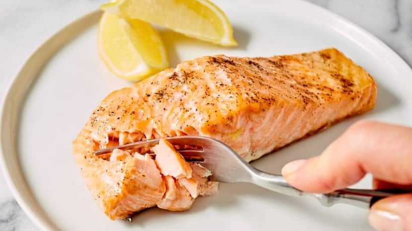 fork cutting into flaky salmon filet