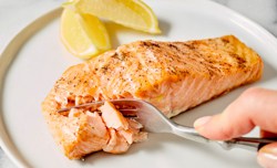 flaking off the salmon with a fork