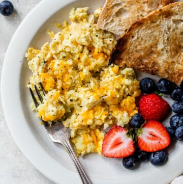Scrambled eggs with cauliflower served with berries and toast.