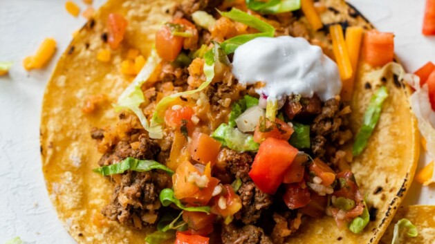 Taco made with taco meat with cauliflower rice, lettuce, sour cream, cheese and tomatoes.