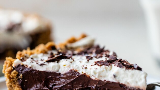 Chocolate avocado pie on a white plate made with a graham cracker crust.
