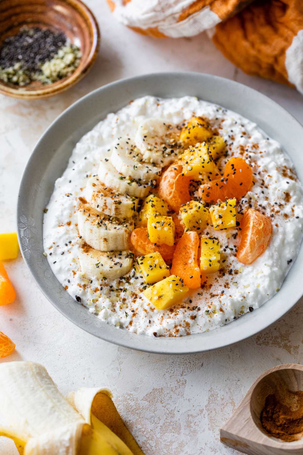 Cottage cheese bowl topped with fruit and seeds.