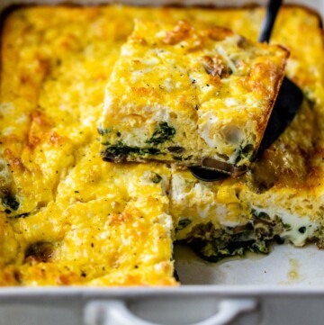 Serving a slice of egg casserole out of a dish.