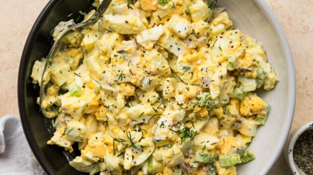 Egg salad in a bowl with a serving spoon.