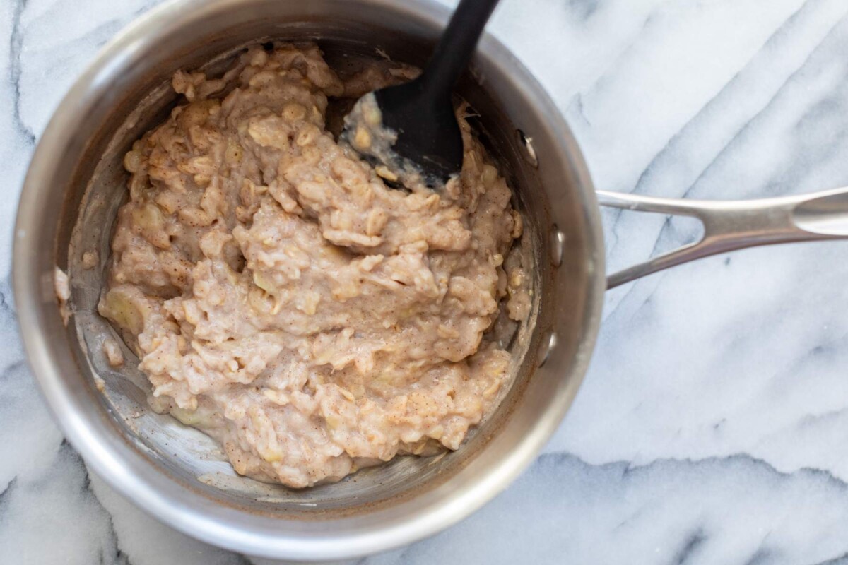 Stirring thick egg white oatmeal in a pot.