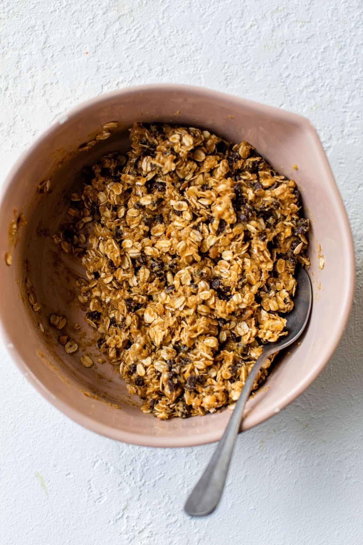 stirring together oats, honey, peanut butter and chocolate chips in a bowl