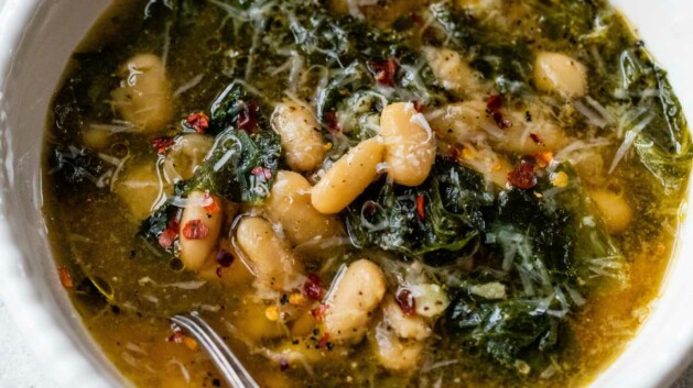 Escarole and beans in a bowl with a spoon.
