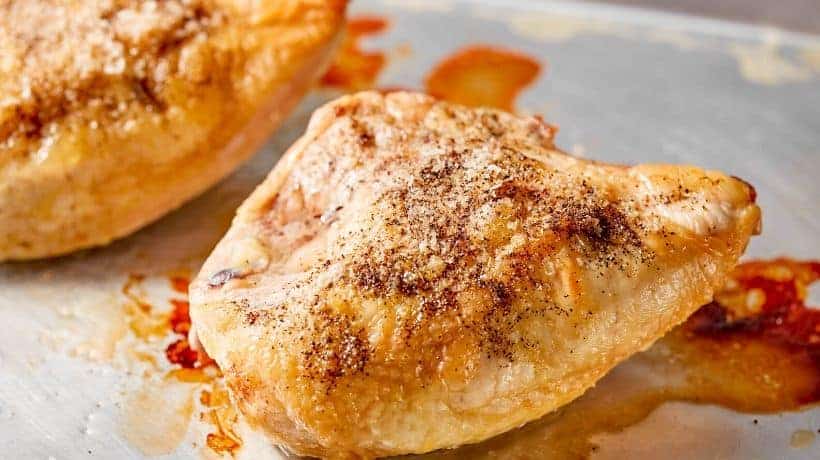 baked bone-in chicken breast on a baking pan