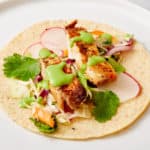 open-faced fish taco on white plate