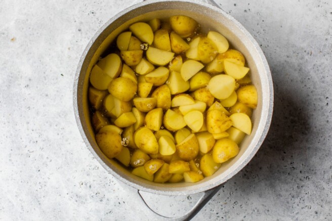 Chopped red potatoes in a pot of water.
