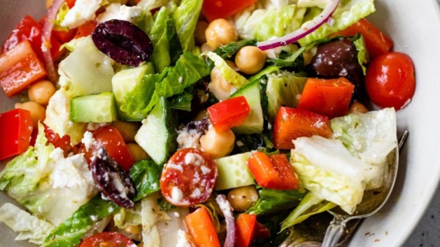 Salad with red bell pepper, olives and chickpeas in a bowl.