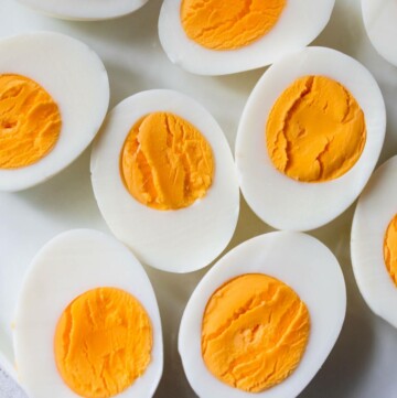 Sliced in half hard-boiled eggs on a white plate.