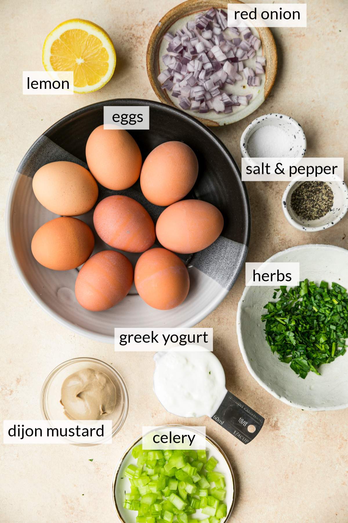Bowls with eggs, onion, celery, Greek yogurt and herbs.