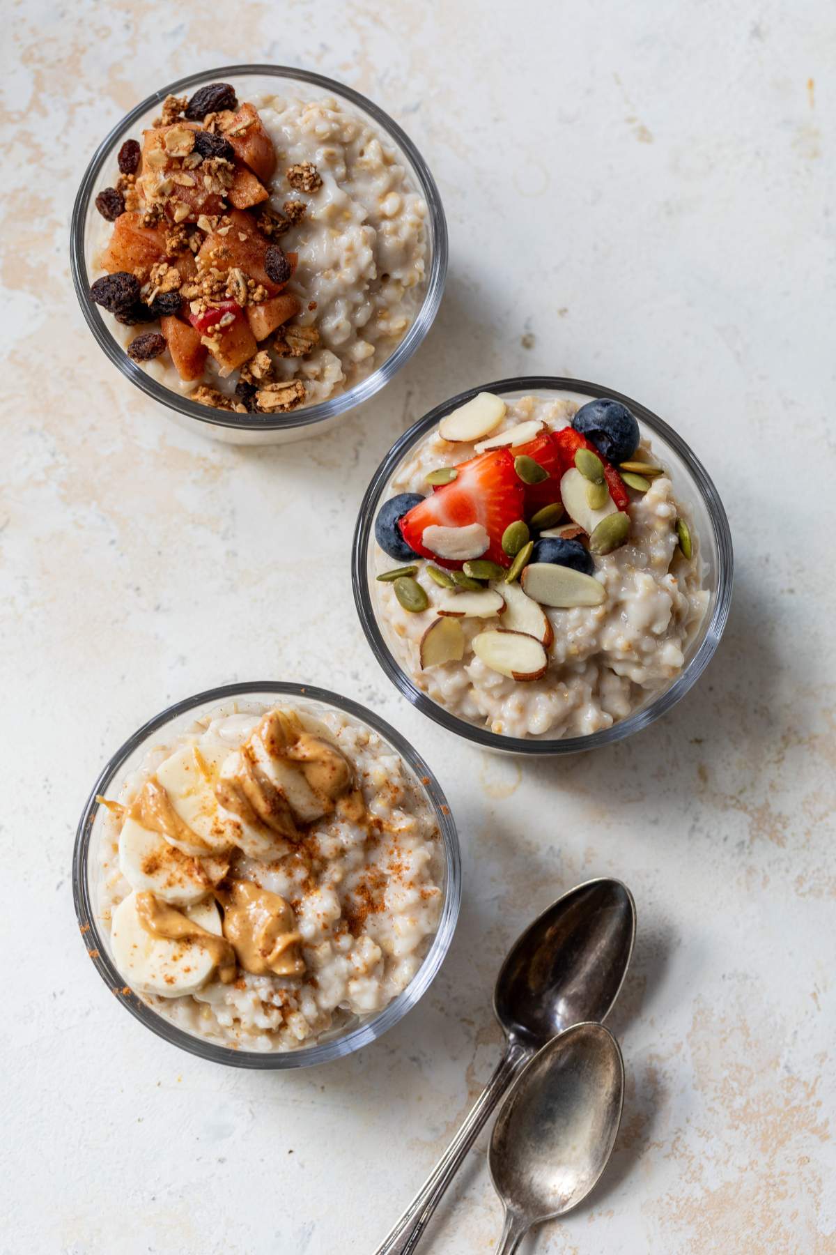 Three bowls of overnight steel cut oats topped with various toppings.