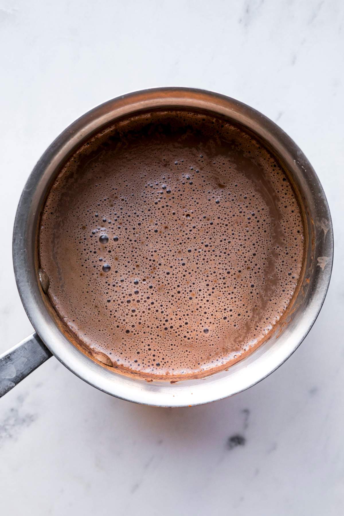 Heating hot chocolate ingredients in a pot.