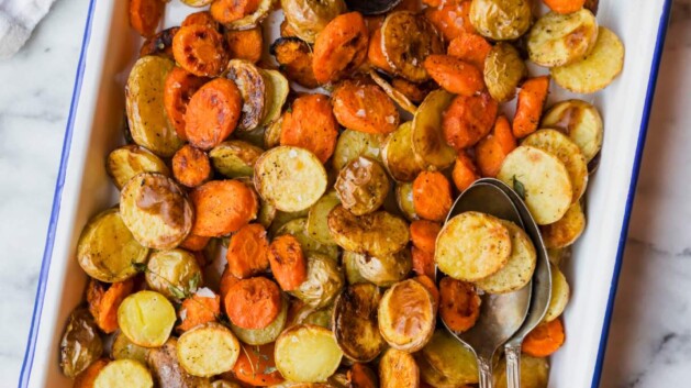 Roasted carrots and baby potatoes on a serving tray.