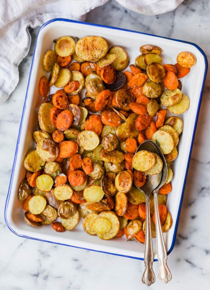 Roasted carrots and baby potatoes on a serving tray.