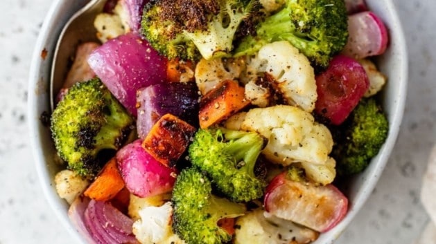 roasted vegetables served in a white bowl with a fork