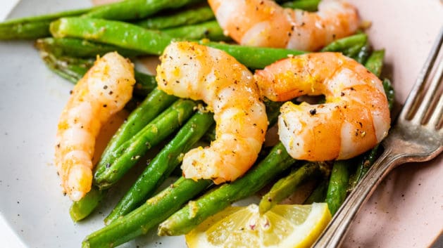 shrimp and green beans on small plate with fork