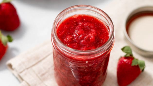strawberry chia jam in a mason jar with peanut butter toast