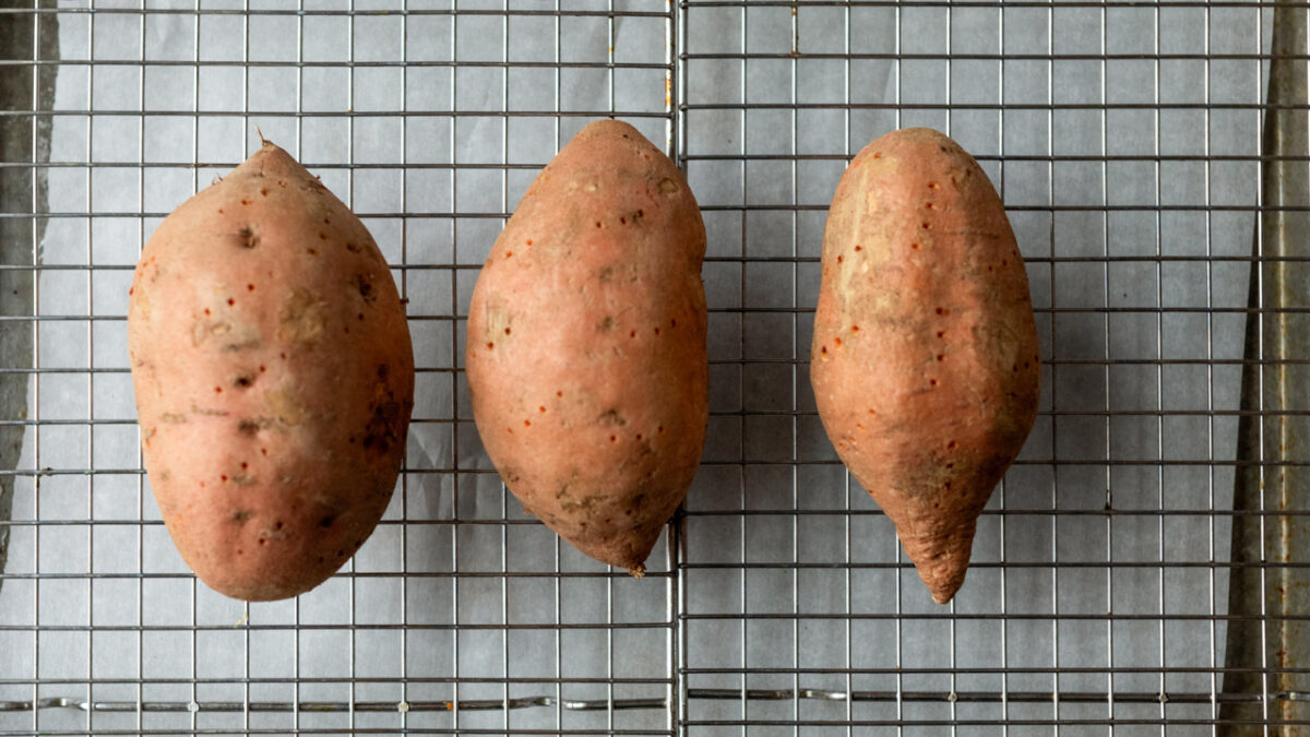 sweet potato prepped on a baking sheet with holes poked