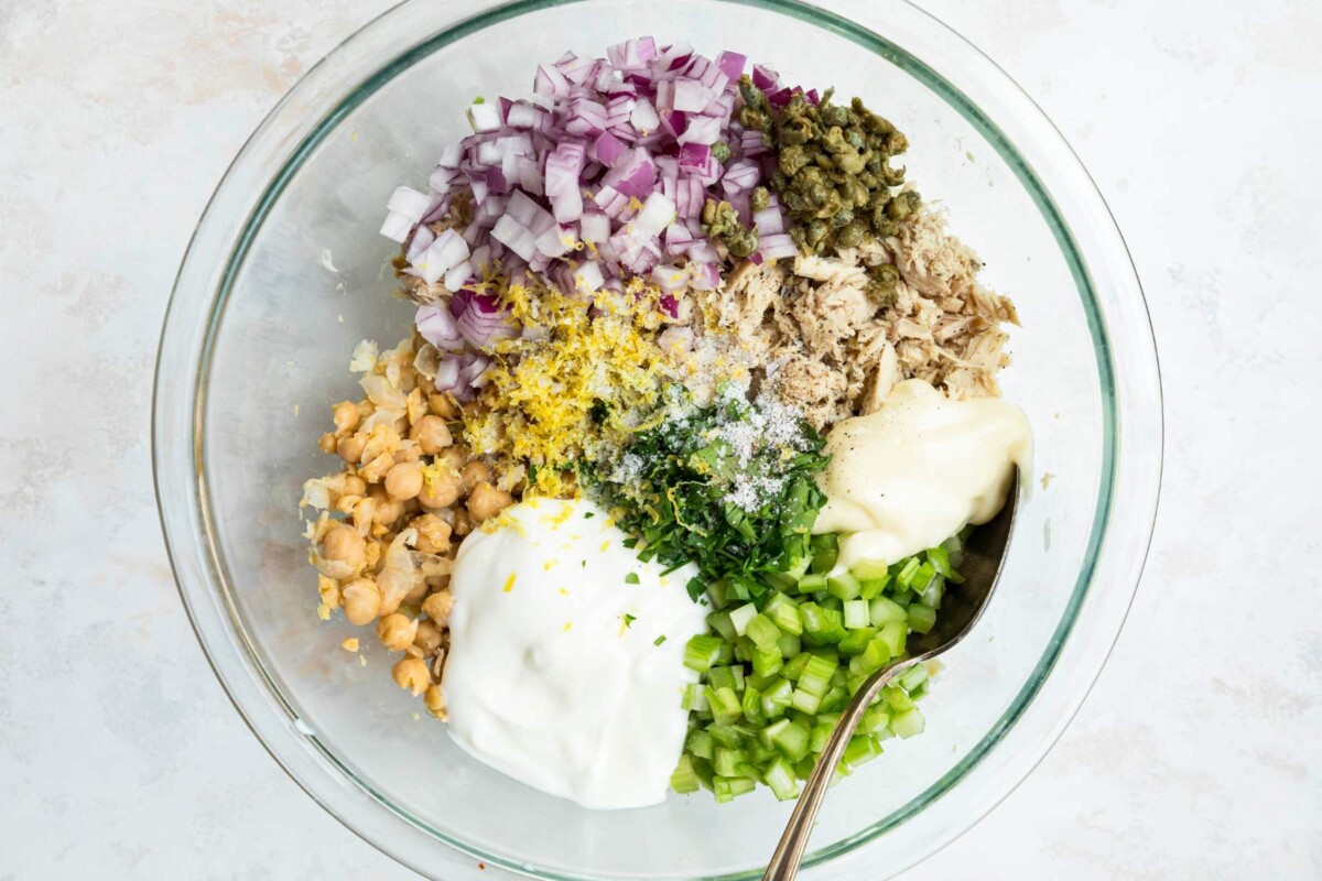 Tuna chickpea salad ingredients added to a large bowl.