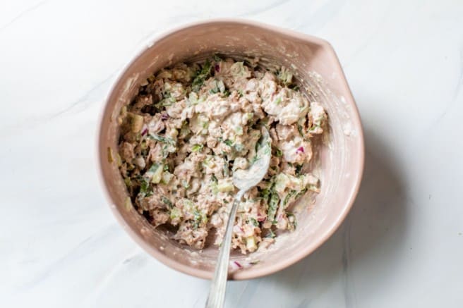 mixing ingredients in a large bowl to make tuna salad