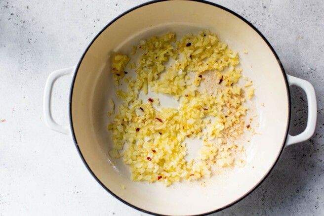 Sautéing onion and garlic in a large pot.