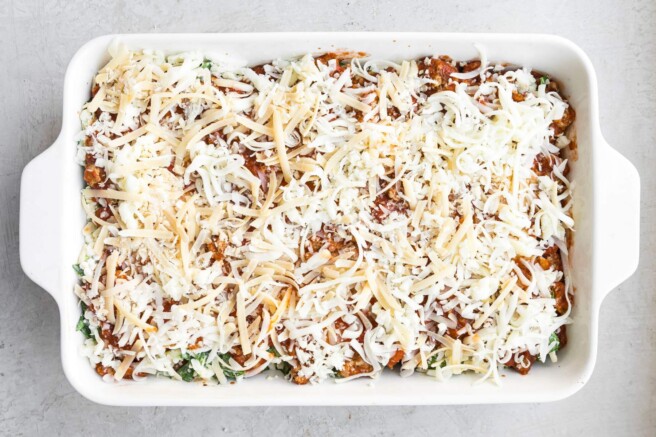 Unbaked lasagna topped with mozzarella cheese.