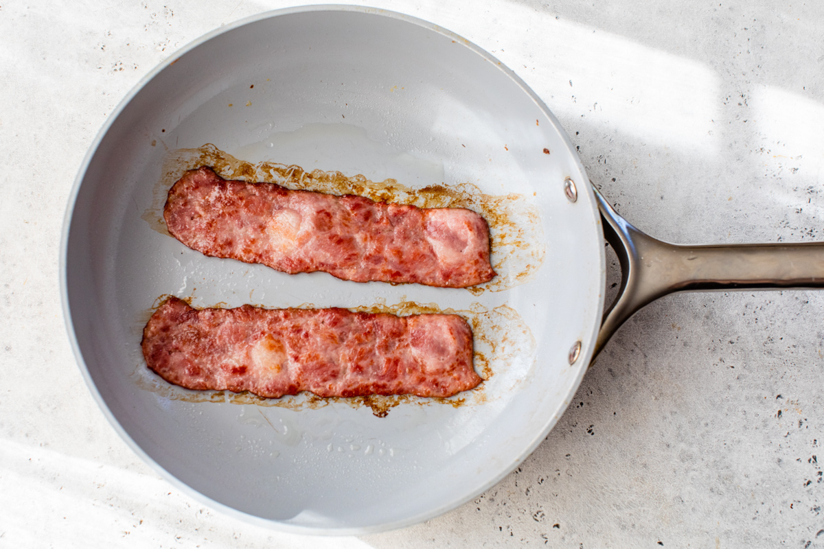 turkey bacon cooking in a saute pan