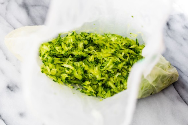 Squeezing excess water out of grated cucumber.