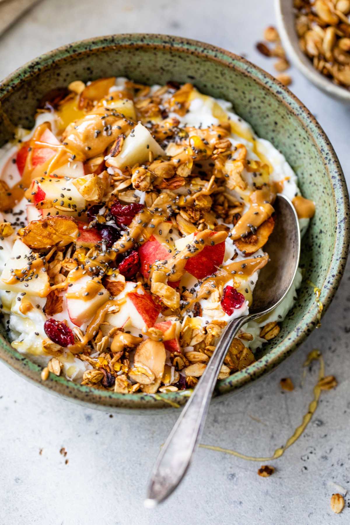 Yogurt with granola, apple and topped with honey and chia seeds.