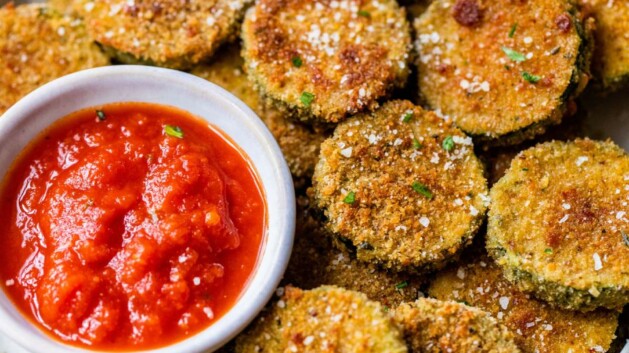 Zucchini chips served on a plate with marinara.